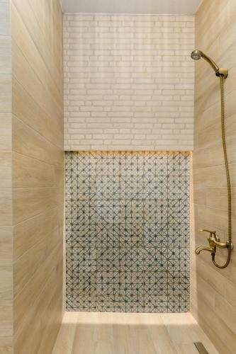 a shower in a bathroom with a tile wall at Meydani Suites in Litochoro