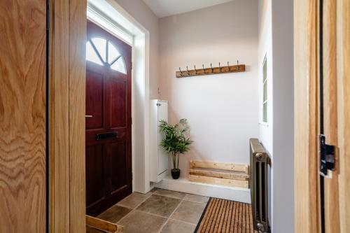 a hallway with a door and a potted plant at Holmfield House in Clayton West