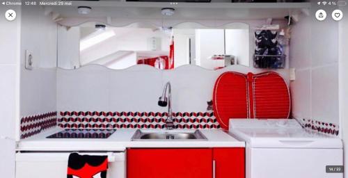 eine Küche mit roten und weißen Schränken und einem Waschbecken in der Unterkunft Studio atypique central mais calme, quartier VIP, plage 50m in Nizza
