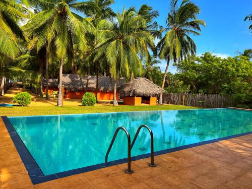a swimming pool in front of a resort at Roshanne Beach Resort in Kalpitiya