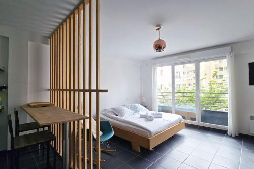 une chambre avec un lit, un bureau et une fenêtre dans l'établissement bnbgônes - Le cosy SAINT LOUIS - METRO JEAN MACE ET SAXE GAMBETTA, à Lyon