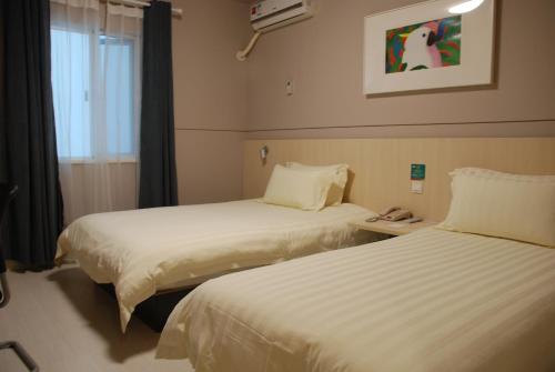 a hotel room with two beds and a window at Jinjiang Inn Xiamen North Railway Station Jiageng Sports Stadium in Xiamen
