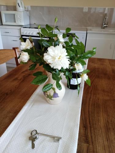 un vase rempli de fleurs blanches sur une table dans l'établissement Gîte de l'Aubespy, à Saint-Pierre-la-Roche
