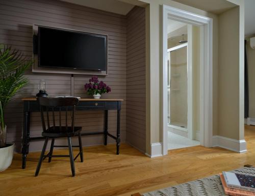 a room with a desk and a television on a wall at Landmark Inn in Cooperstown