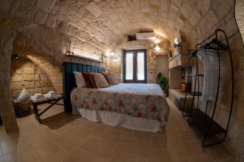 een slaapkamer met een bed in een stenen muur bij Dimora 181 in Polignano a Mare