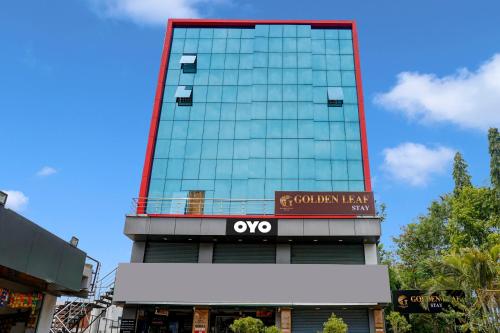 a tall glass building with a sign on it at Collection O Golden Leaf in Pune
