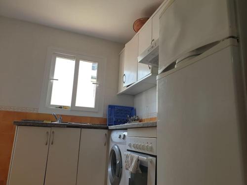 a kitchen with a sink and a washer and a window at Appartement in Cherarba