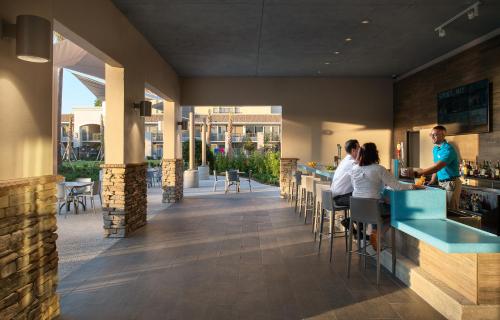 a rendering of a restaurant with people sitting at the bar at Wyndham I-Drive Avanti Resort & Conference Center in Orlando