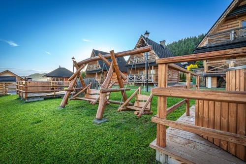 a wooden playground in front of a lodge at Osada Szaflary in Szaflary