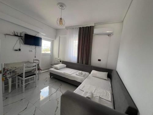 a room with two beds and a table in it at Vila Kylie in Ksamil