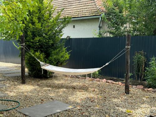 a hammock hanging from two poles in a garden at Kékmadár Vendégház Alsómégy in Homokmégy