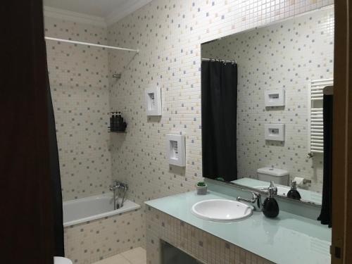 a bathroom with a sink and a mirror at Hollywood Apartment in Bragança