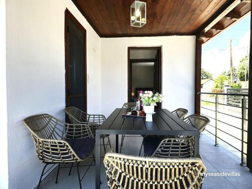 Una mesa y sillas negras en un patio. en Summertime Villa just 90meters from the sea!, en Sozopoli