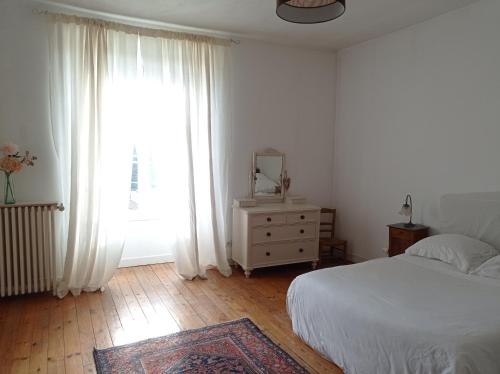 a bedroom with a bed and a dresser and a window at La maison de Nina in Pont-Sainte-Maxence