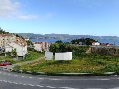 a road with a view of a town and a lake at Gran Paraíso Raxo in Raxo