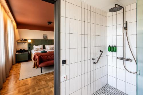 a bathroom with a shower and a bedroom at Hotel Fratelli in Karlstad