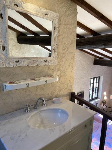 une salle de bain avec un lavabo et un miroir dans l'établissement Les bergeries de DANIELLE, à Draguignan