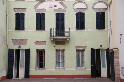 a building with black shuttered windows and a balcony at Hotel Antica Dimora, MantegnaHotels in Mantova