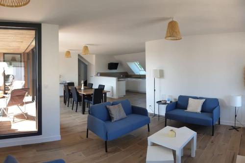 un salon avec des chaises bleues et une salle à manger dans l'établissement Les Hauts de la Belle Époque, à Carnac