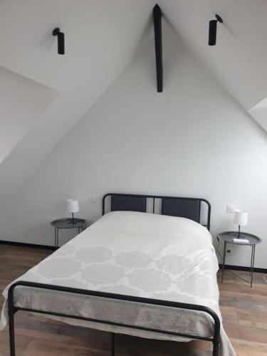 - un lit dans une chambre avec 2 tables de chevet dans l'établissement Les Hauts de la Belle Époque, à Carnac