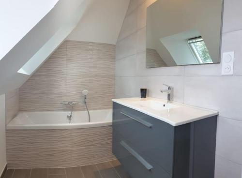 une salle de bain avec un lavabo et une baignoire dans l'établissement Les Hauts de la Belle Époque, à Carnac