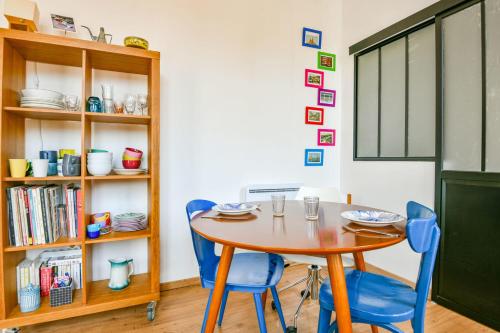 une salle à manger avec une table et des chaises bleues dans l'établissement Appart cosy à 5 min de la plage des Catalans, à Marseille