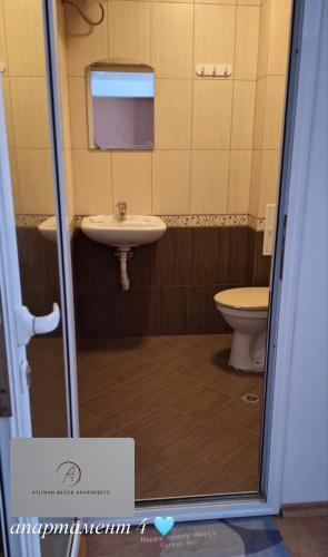 a bathroom with a sink and a toilet at Atliman Beach Apartment 1 in Kiten