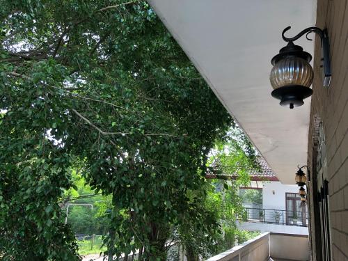 a light hanging from a building with a tree at Murphy's Transit Villa Airport Pick & Drop Katunayake in Katunayake