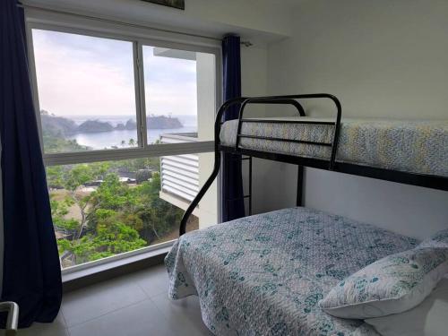 Un dormitorio con una litera y una ventana grande. en Ocean View steps to the beach, en Punta Leona