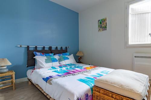 une chambre avec un grand lit aux murs bleus dans l'établissement La joie de vivre: logement entier, parking privé, à Sainte-Savine