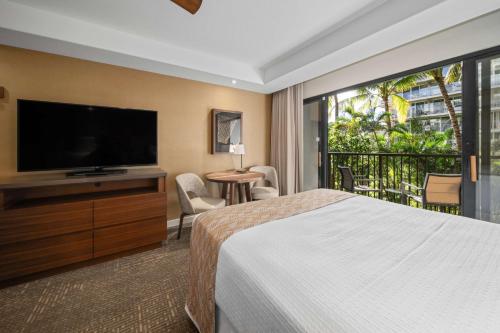 ein Hotelzimmer mit einem Bett und einem Flachbild-TV in der Unterkunft OUTRIGGER Kāʻanapali Beach Resort in Lahaina