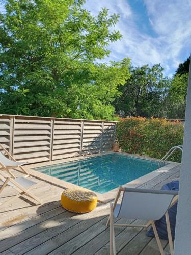 - une piscine sur une terrasse en bois avec une chaise dans l'établissement Villa Lambesc Provence, à Lambesc