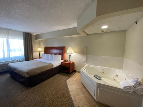 a hotel room with a bed and a bath tub at MountainView Lodge and Suites in Bozeman