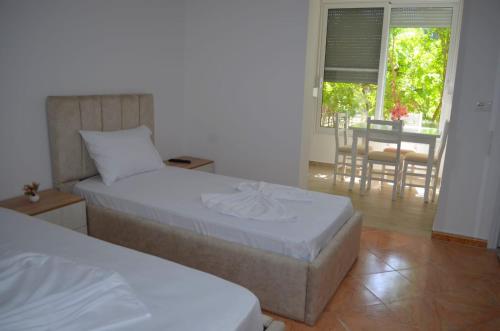 a bedroom with two beds and a dining room with a table at Vila Sinomati in Vlorë