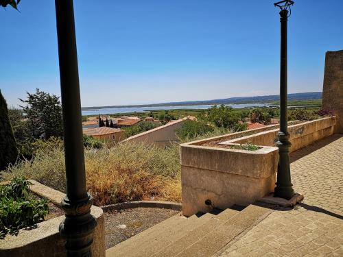 a street light on a sidewalk with a view of the ocean at maison du portail vieil in Vendres