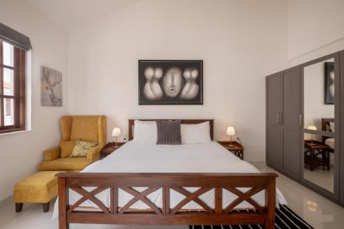 um quarto com uma cama e uma cadeira em Staymaster Amber Avenue I 3BR em Verla
