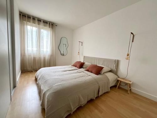 une chambre blanche avec un grand lit et une fenêtre dans l'établissement Appartement 3 chambres, à Clamart