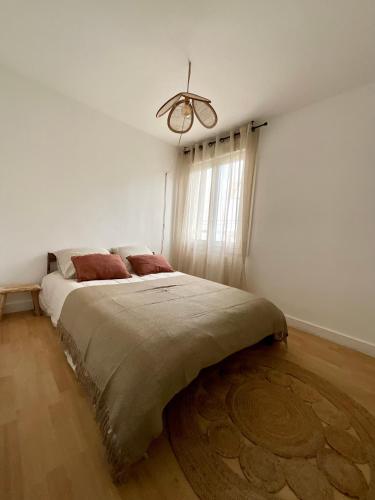 une chambre avec un grand lit dans une pièce blanche dans l'établissement Appartement 3 chambres, à Clamart