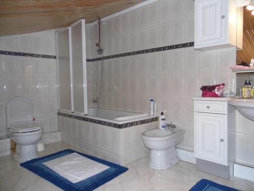 une salle de bain avec une baignoire, des toilettes et un lavabo dans l'établissement Gîte en pierre avec piscine Cordes-Ciel, à Cordes-sur-Ciel