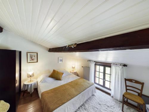 une chambre avec un grand lit et une fenêtre dans l'établissement Gîte en pierre avec piscine Cordes-Ciel, à Cordes-sur-Ciel