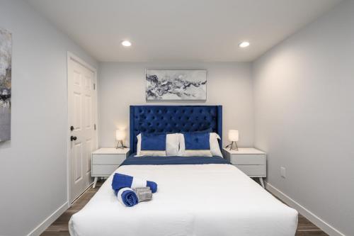 ein Schlafzimmer mit einem großen Bett mit blauem Kopfteil in der Unterkunft Luxury 4 Bedroom House Mins to Disney! Game Room in Westminster
