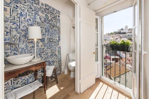 a bathroom with a toilet and a window at Alfama - St Estevão viewpoint | Lisbon Cheese & Wine Apartments in Lisbon