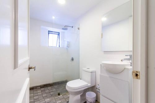 a white bathroom with a toilet and a sink at Casa Alhaja - Diamante in Guadalajara