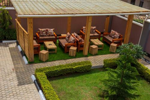 a backyard with a gazebo with couches and tables at Occazia Hotel in Mbarara