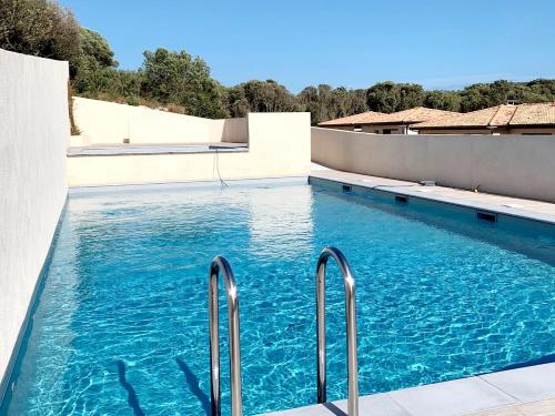 - une piscine d'eau bleue dans un bâtiment dans l'établissement Résidence Confort avec Piscine - Proche des plages, à Bonifacio