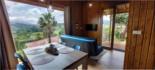 a dining room with a table and a large window at Fernandes Guest house Blue bungalow in Ponte de Lima