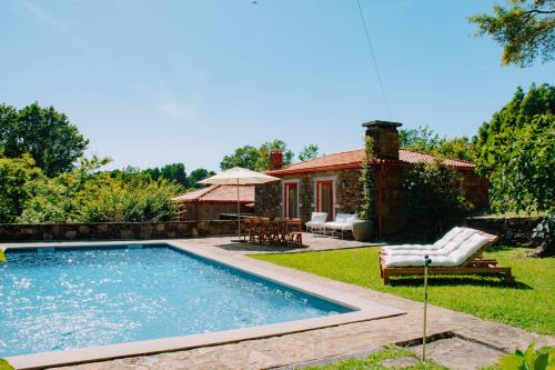 a swimming pool in the yard of a house at Just Like Home - Casa da Raposa in Caminha