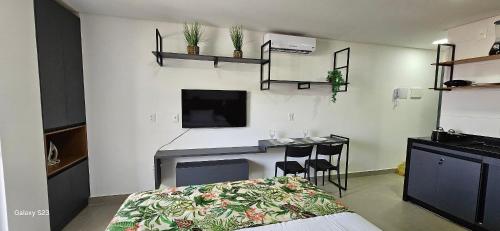 a bedroom with a bed and a desk and a tv at Flats Tramonto - By EasyHost in João Pessoa