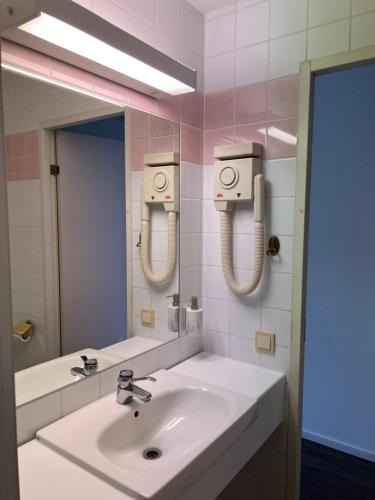 y baño con lavabo blanco y espejo. en Hotell City Karlshamn en Karlshamn