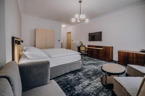 a hotel room with a bed and a couch at Esplanade Carlsbad in Karlovy Vary